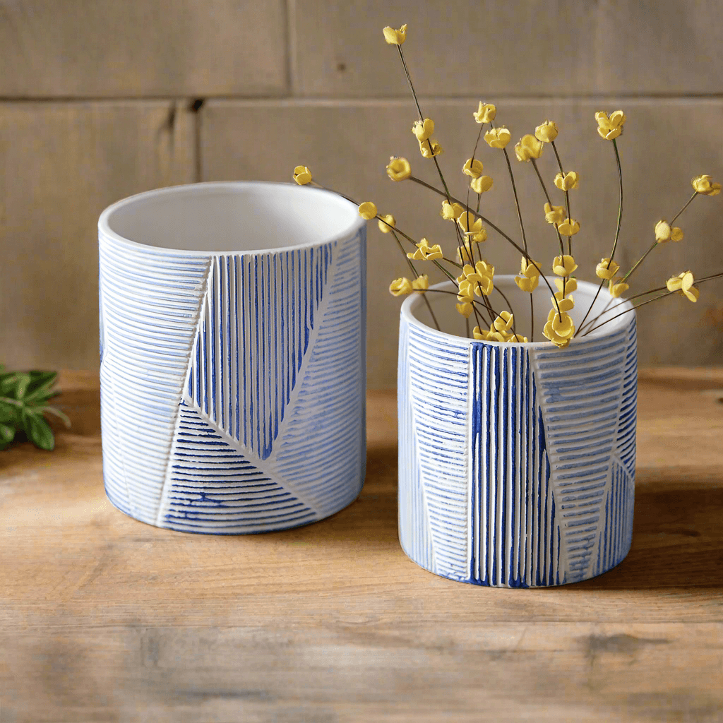 Blue and white geometric textured ceramic pots with dried flowers, stylish home decor for plants and storage.