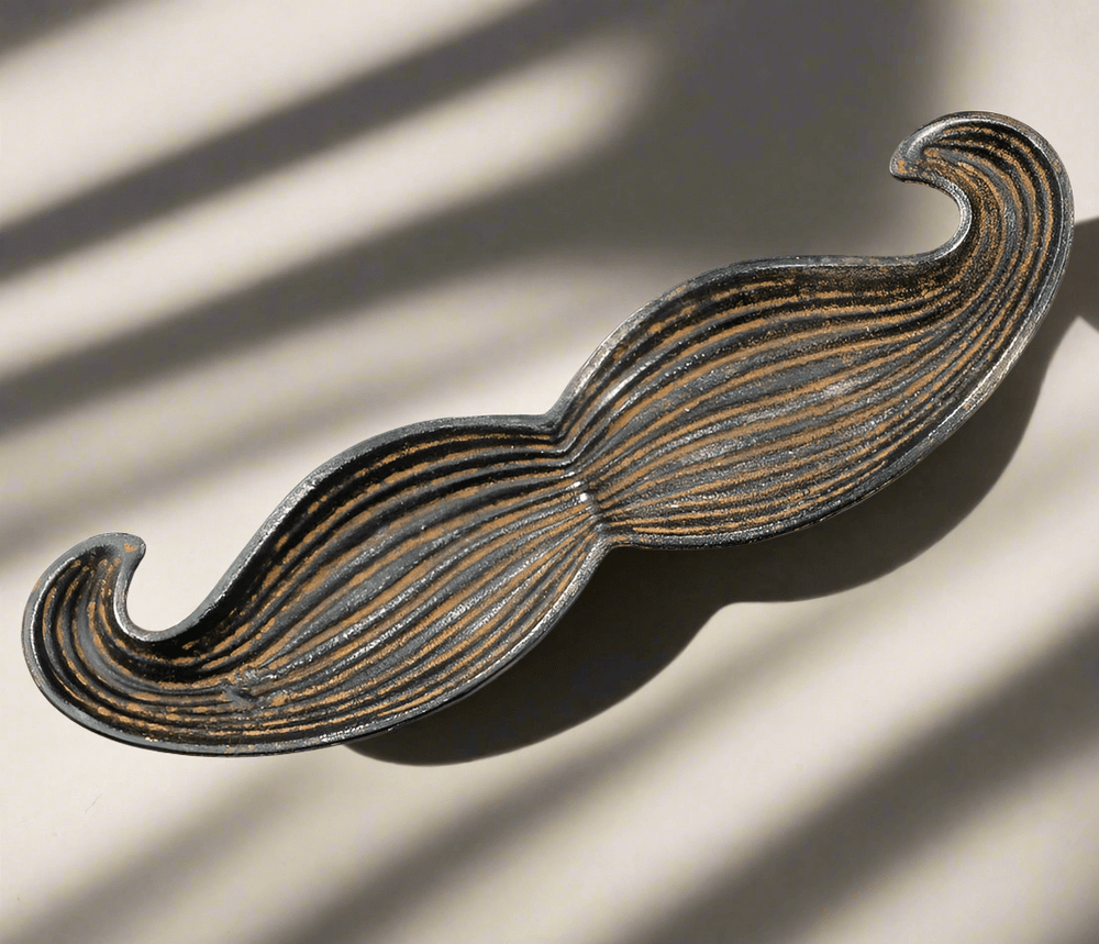 Mustache-shaped cast iron tray with textured vintage finish, perfect for adding whimsy to home décor. Set of 2.