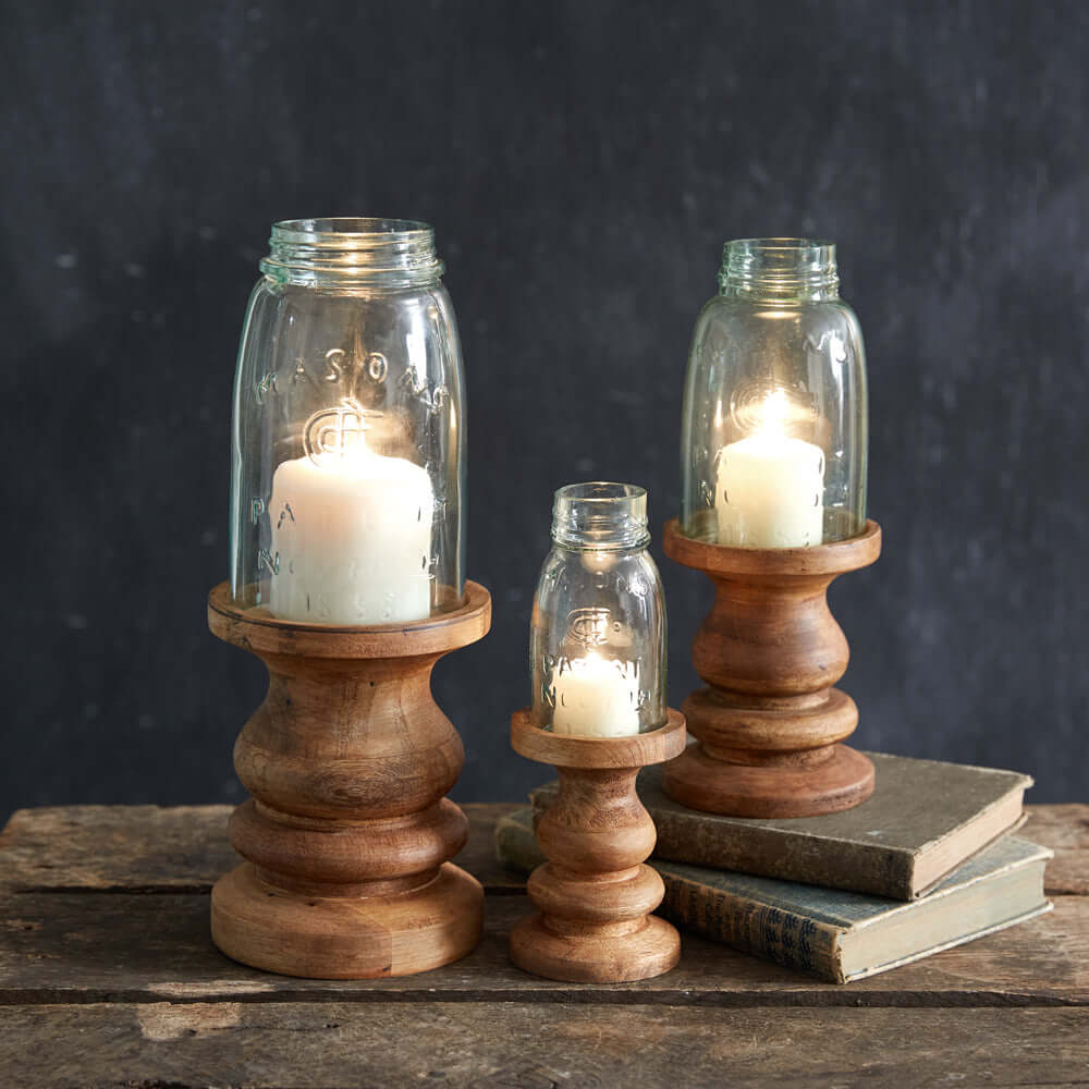 Rustic farmhouse candle holders with Mason jars and wooden bases, creating a warm ambiance on a vintage table.