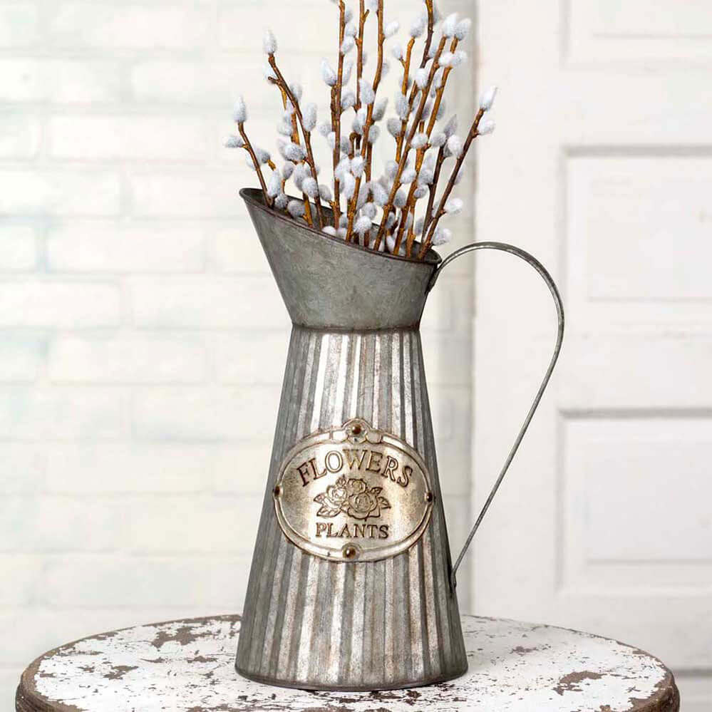 Rustic farmhouse metal pitcher vase with embossed label for flowers and plants, featuring a distressed corrugated design.