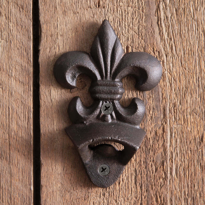 Fleur-de-Lis wall-mounted bottle opener in cast iron, showcasing vintage design on rustic wooden background.