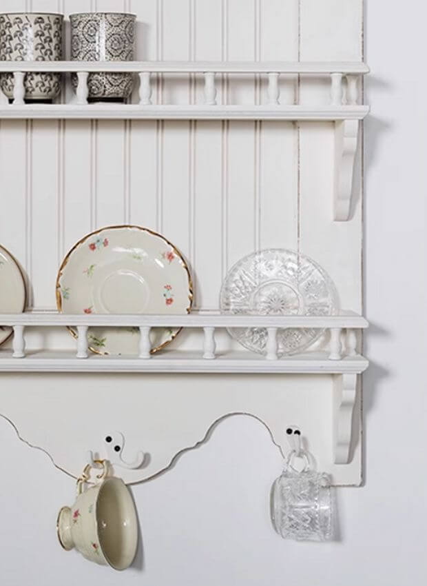 Elegant French Country wall-mounted dish rack showcasing vintage dishware and glassware in a classic white finish.