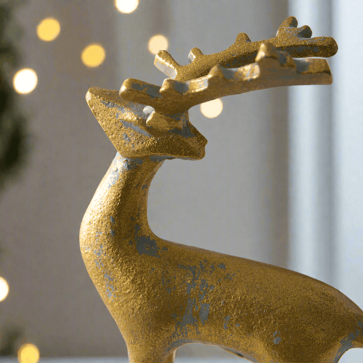 Elegant gold reindeer figurine with intricate details, perfect for holiday decorations and festive displays.