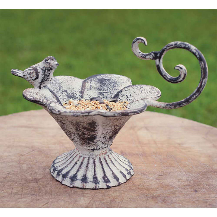 Rustic cast iron bird feeder with flower-shaped basin and whimsical bird figurine, perfect for garden decor.