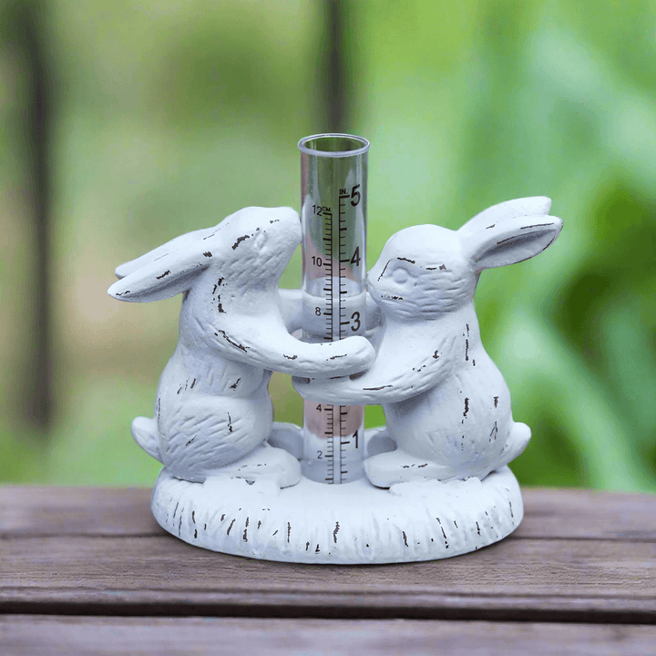 Weathered Rabbits Rain Gauge with clear measuring tube, perfect for adding rustic charm to gardens and patios.