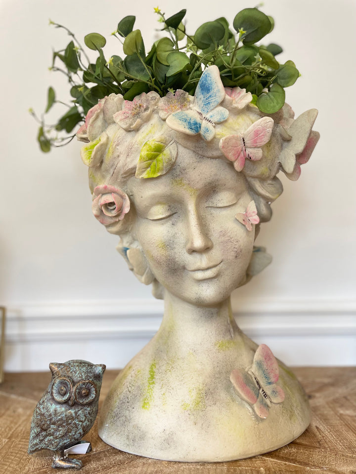 Whimsical Butterfly Goddess Planter with floral accents and greenery, perfect for succulents and blooms.