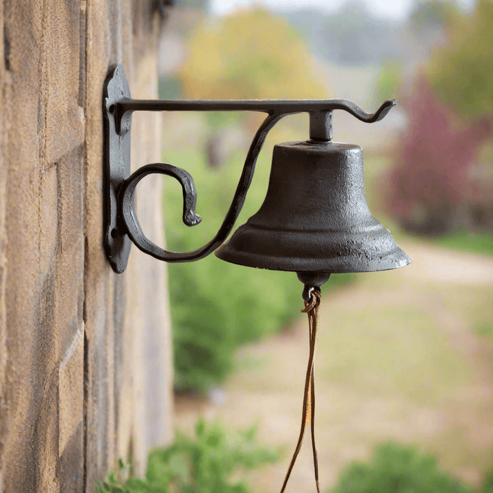 Vintage wall-mounted farmhouse bell made of durable cast iron, perfect for rustic home or garden decor.