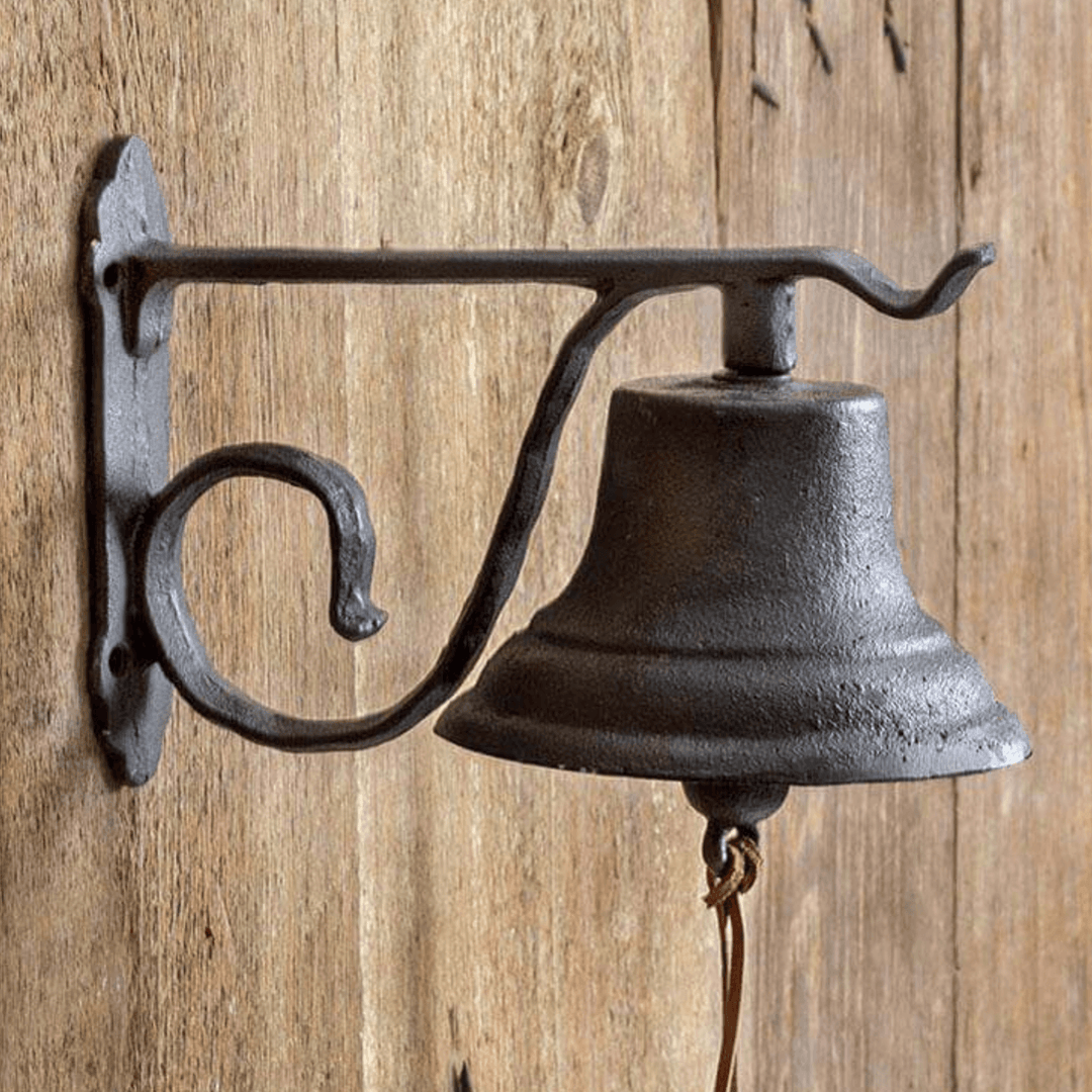 Vintage wall-mounted farmhouse bell crafted from durable cast iron, adding rustic charm to home or garden decor.